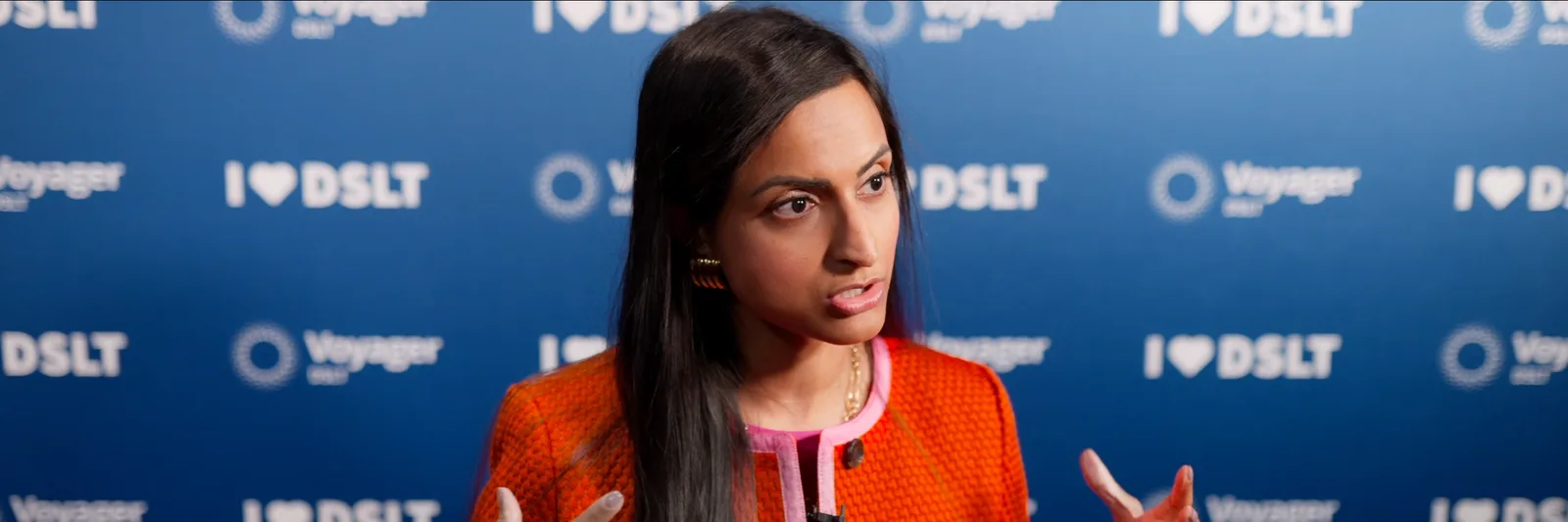 Conference interview in front of a step-and-repeat wall